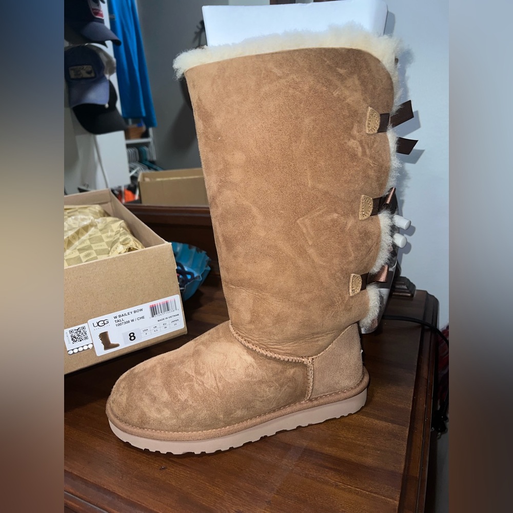 Tall brown UGG boots with bows in the back
